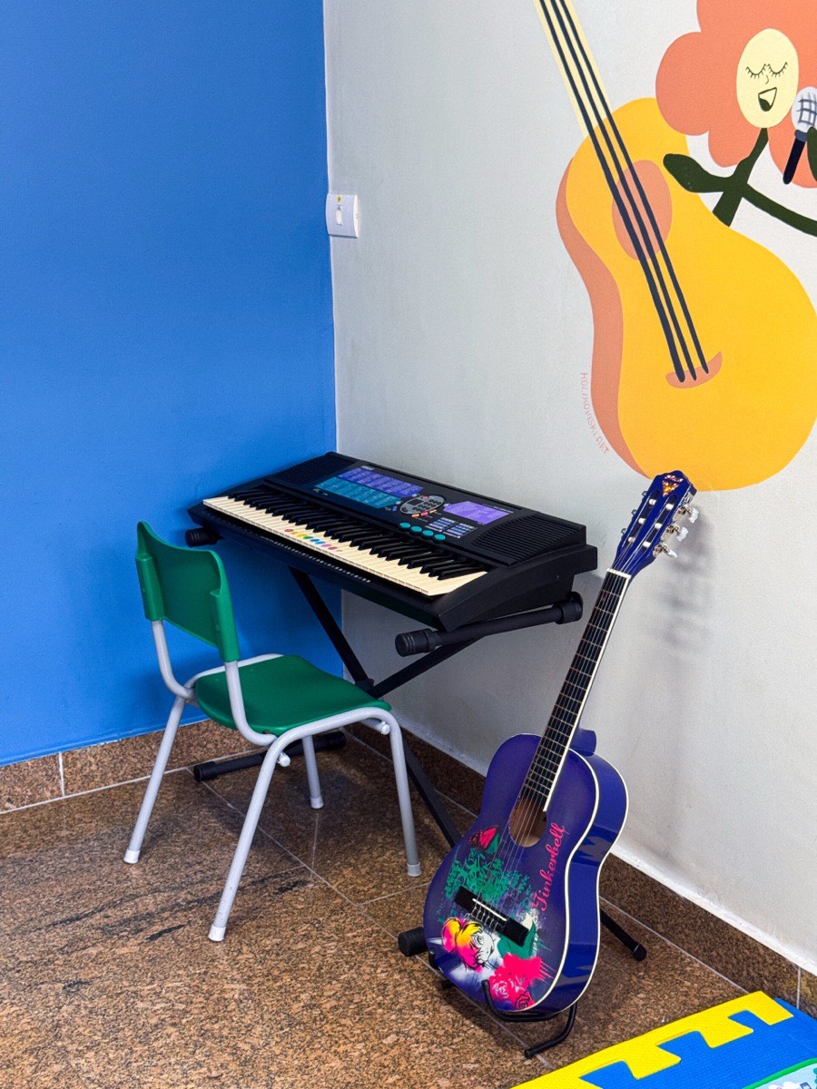 Sala de musicoterapia com teclado e violão
