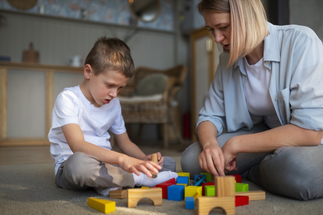 Mãe brincando com seu filho autista usando brinquedos